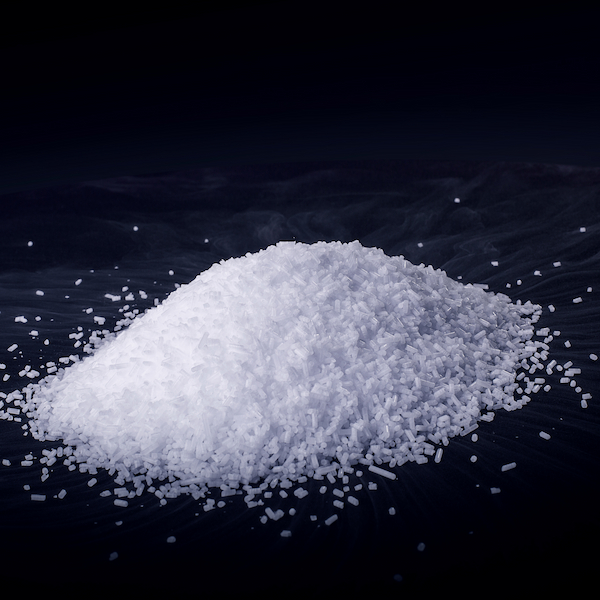 Haufen aus kleinen, weißen Trockeneis-Micropellets mit leichtem Nebel, ideal für Strahlen und Kühlprozesse.