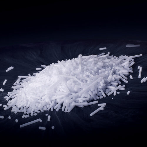 Haufen aus länglichen weißen Trockeneis-Pellets mit CO₂-Nebel, geeignet für industrielle Anwendungen.