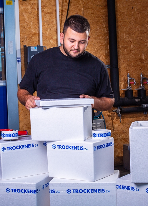 Sichere Verpackung mit Trockeneis24 Mitarbeiter verpackt Trockeneis in Styroporboxen mit Trockeneis24 Aufschrift