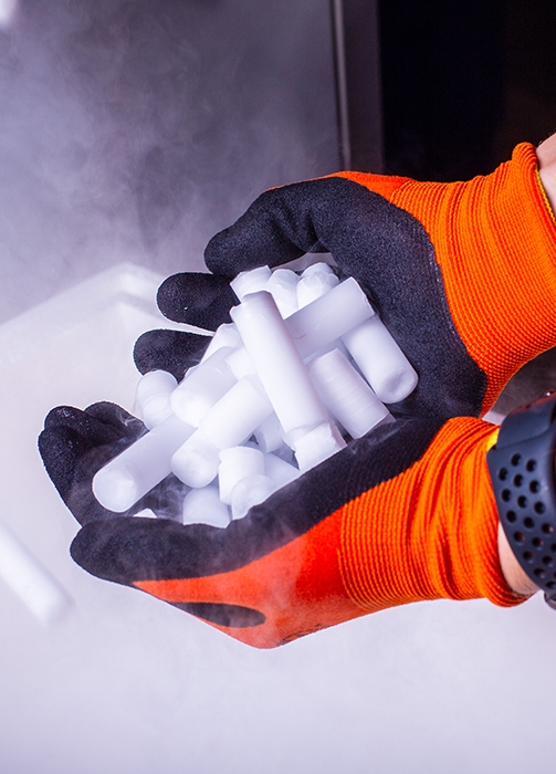 Sichere Handhabung mit Trockeneis von Trockeneis24 Nahaufnahme von Händen mit Schutzhandschuhen, die frische Trockeneis-Pellets halten.