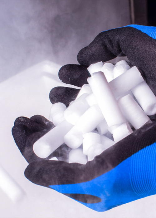 Sichere Handhabung mit Trockeneis von Trockeneis24 Nahaufnahme von Händen mit Schutzhandschuhen, die frische Trockeneis-Pellets halten.